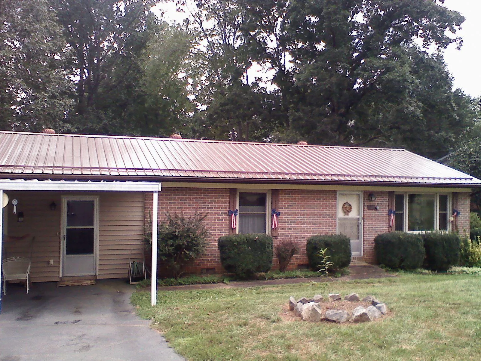 Bronze metal roof and carport on a brick ranch home — Roof Repair work by our crew in Henrietta